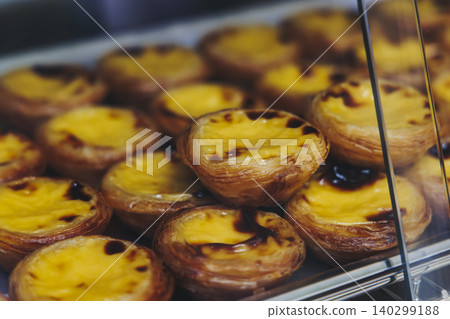 Pasteis and Pastel de nata, traditional Portuguese egg custard tart pasty cakes, dessert Pasteis de nata with different pastry in the cafe, bakery display window, Pastel de belem, Lisbon, Portugal Pasteis and Pastel de nata, traditional Portuguese egg custard tart pasty cakes, dessert Pasteis de nata with different pastry in the cafe, bakery display window, Pastel de belem, Lisbon, Portugal 140299188