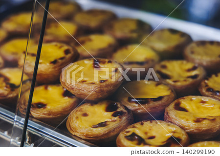 Pasteis and Pastel de nata, traditional Portuguese egg custard tart pasty cakes, dessert Pasteis de nata with different pastry in the cafe, bakery display window, Pastel de belem, Lisbon, Portugal Pasteis and Pastel de nata, traditional Portuguese egg custard tart pasty cakes, dessert Pasteis de nata with different pastry in the cafe, bakery display window, Pastel de belem, Lisbon, Portugal 140299190