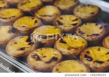 Pasteis and Pastel de nata, traditional Portuguese egg custard tart pasty cakes, dessert Pasteis de nata with different pastry in the cafe, bakery display window, Pastel de belem, Lisbon, Portugal Pasteis and Pastel de nata, traditional Portuguese egg custard tart pasty cakes, dessert Pasteis de nata with different pastry in the cafe, bakery display window, Pastel de belem, Lisbon, Portugal 140299201