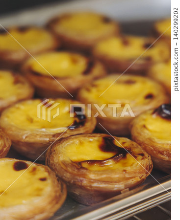 Pasteis and Pastel de nata, traditional Portuguese egg custard tart pasty cakes, dessert Pasteis de nata with different pastry in the cafe, bakery display window, Pastel de belem, Lisbon, Portugal Pasteis and Pastel de nata, traditional Portuguese egg custard tart pasty cakes, dessert Pasteis de nata with different pastry in the cafe, bakery display window, Pastel de belem, Lisbon, Portugal 140299202