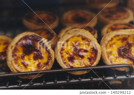 Pasteis and Pastel de nata, traditional Portuguese egg custard tart pasty cakes, dessert Pasteis de nata with different pastry in the cafe, bakery display window, Pastel de belem, Lisbon, Portugal Pasteis and Pastel de nata, traditional Portuguese egg custard tart pasty cakes, dessert Pasteis de nata with different pastry in the cafe, bakery display window, Pastel de belem, Lisbon, Portugal 140299212