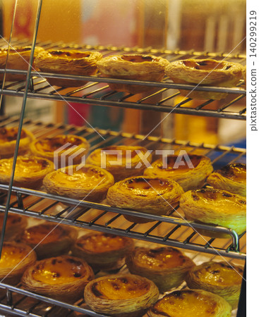 Pasteis and Pastel de nata, traditional Portuguese egg custard tart pasty cakes, dessert Pasteis de nata with different pastry in the cafe, bakery display window, Pastel de belem, Lisbon, Portugal Pasteis and Pastel de nata, traditional Portuguese egg custard tart pasty cakes, dessert Pasteis de nata with different pastry in the cafe, bakery display window, Pastel de belem, Lisbon, Portugal 140299219