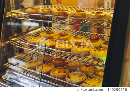 Pasteis and Pastel de nata, traditional Portuguese egg custard tart pasty cakes, dessert Pasteis de nata with different pastry in the cafe, bakery display window, Pastel de belem, Lisbon, Portugal Pasteis and Pastel de nata, traditional Portuguese egg custard tart pasty cakes, dessert Pasteis de nata with different pastry in the cafe, bakery display window, Pastel de belem, Lisbon, Portugal 140299256