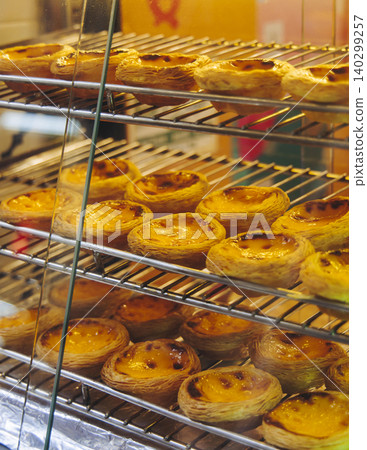 Pasteis and Pastel de nata, traditional Portuguese egg custard tart pasty cakes, dessert Pasteis de nata with different pastry in the cafe, bakery display window, Pastel de belem, Lisbon, Portugal Pasteis and Pastel de nata, traditional Portuguese egg custard tart pasty cakes, dessert Pasteis de nata with different pastry in the cafe, bakery display window, Pastel de belem, Lisbon, Portugal 140299257