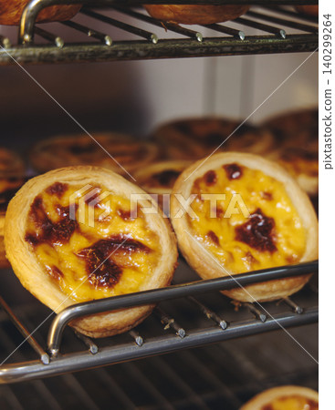 Pasteis and Pastel de nata, traditional Portuguese egg custard tart pasty cakes, dessert Pasteis de nata with different pastry in the cafe, bakery display window, Pastel de belem, Lisbon, Portugal Pasteis and Pastel de nata, traditional Portuguese egg custard tart pasty cakes, dessert Pasteis de nata with different pastry in the cafe, bakery display window, Pastel de belem, Lisbon, Portugal 140299264