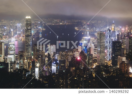 Hong Kong night evening view, China, seen from Victoria Peak observation deck, Lugard road lookout, with Hong Kong downtown skyscrapers and Kowloon island, illuminated city and Victoria Bay at night Hong Kong night evening view, China, seen from Victoria Peak observation deck, Lugard road lookout, with Hong Kong downtown skyscrapers and Kowloon island, illuminated city and Victoria Bay at night 140299292