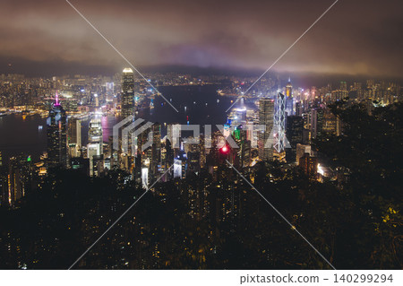 Hong Kong night evening view, China, seen from Victoria Peak observation deck, Lugard road lookout, with Hong Kong downtown skyscrapers and Kowloon island, illuminated city and Victoria Bay at night Hong Kong night evening view, China, seen from Victoria Peak observation deck, Lugard road lookout, with Hong Kong downtown skyscrapers and Kowloon island, illuminated city and Victoria Bay at night 140299294