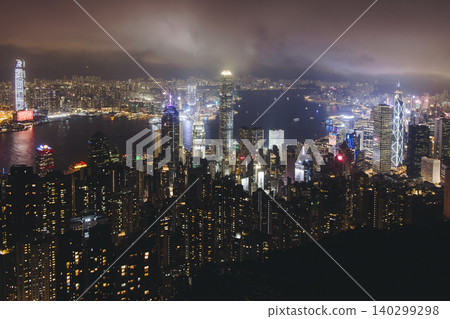 Hong Kong night evening view, China, seen from Victoria Peak observation deck, Lugard road lookout, with Hong Kong downtown skyscrapers and Kowloon island, illuminated city and Victoria Bay at night Hong Kong night evening view, China, seen from Victoria Peak observation deck, Lugard road lookout, with Hong Kong downtown skyscrapers and Kowloon island, illuminated city and Victoria Bay at night 140299298