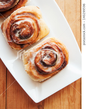 Sweet homemade cinnamon rolls with coffee for breakfast, freshly baked cinnabons with cream cheese. 140299596