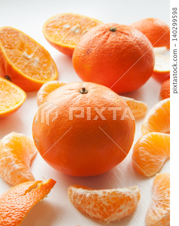 Fresh ripe tangerines on white background, juicy citrus orange fruits peeled lying on wooden table. Fresh ripe tangerines on white background, juicy citrus orange fruits peeled lying on wooden table. 140299598