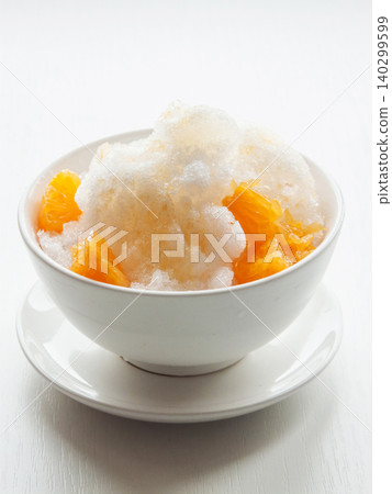 Shaved ice Kakigori granita fruit dessert for summer made of ice with juice sauce in bowl on table. Shaved ice Kakigori granita fruit dessert for summer made of ice with juice sauce in bowl on table. 140299599