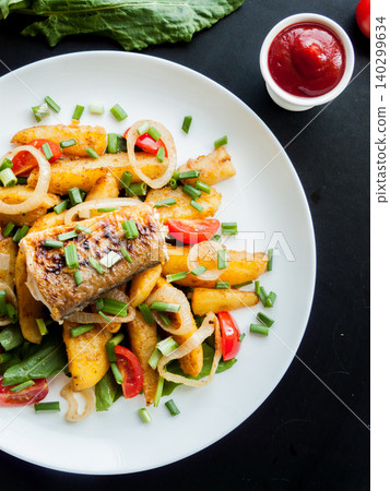 Cooking and healthy eating concept. Plate with baked potatoes, piece of fish, fish and chips meal. Cooking and healthy eating concept. Plate with baked potatoes, piece of fish, fish and chips meal. 140299634