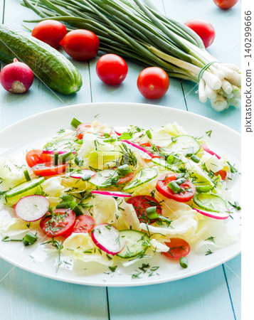 Plate with fresh salad of sliced radish, cherry tomatoes, cucumber, greens and iceberg in olive oil Plate with fresh salad of sliced radish, cherry tomatoes, cucumber, greens and iceberg in olive oil 140299666