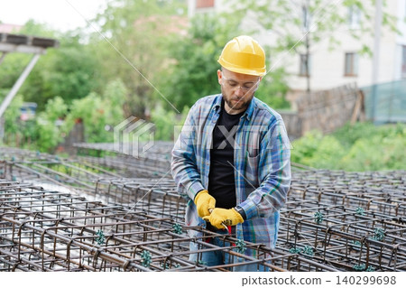Worker checking reinforcing steel bars at construction site Worker checking reinforcing steel bars at construction site 140299698