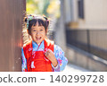 Joyful young Japanese girl in traditional kimono smiles brightly outdoors 140299728
