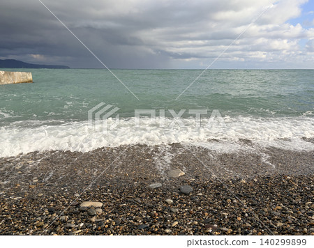 a moody and atmospheric coastal scene where a pebble beach meets the sea. Natural landscape a moody and atmospheric coastal scene where a pebble beach meets the sea. Natural landscape 140299899
