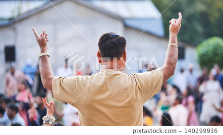Man celebrating Ganesha Chaturthi festival, hands raised in joyful worship Man celebrating Ganesha Chaturthi festival, hands raised in joyful worship 140299936