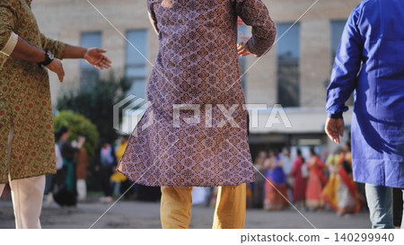 Men wearing traditional kurtas celebrating Ganesh Chaturthi with dancing crowd 140299940