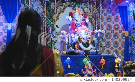 Devotee celebrating Ganesha Chaturthi festival in India, worshipping Lord Ganesha idol Devotee celebrating Ganesha Chaturthi festival in India, worshipping Lord Ganesha idol 140299954