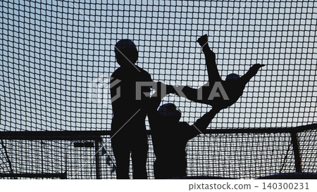 Person silhouette jumping and playing on trampoline with safety net Person silhouette jumping and playing on trampoline with safety net 140300231