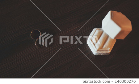 Two gold wedding rings and a hexagonal velvet box on a dark wooden background 140300270