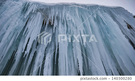 Forming icicles creating a frozen wall of ice during harsh winter conditions Forming icicles creating a frozen wall of ice during harsh winter conditions 140300280