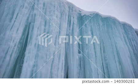 Frozen waterfall creating a dramatic ice wall in a harsh winter landscape Frozen waterfall creating a dramatic ice wall in a harsh winter landscape 140300281