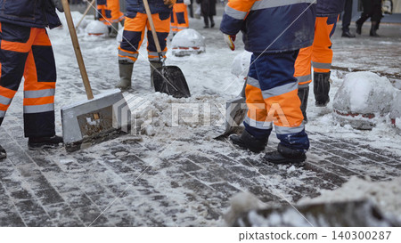 Municipal workers clearing snow from a city sidewalk during harsh winter conditions Municipal workers clearing snow from a city sidewalk during harsh winter conditions 140300287