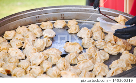 Vendor serving traditional momos at India Day street food festival in Moscow Vendor serving traditional momos at India Day street food festival in Moscow 140300319