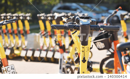 Yellow electric scooters lined up, offering shared urban mobility and new transport options Yellow electric scooters lined up, offering shared urban mobility and new transport options 140300414