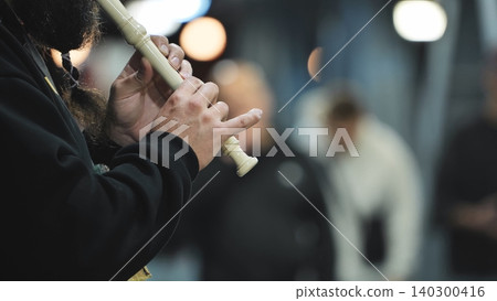 Busker playing recorder, hands pressing keys creating music outdoors, street performance Busker playing recorder, hands pressing keys creating music outdoors, street performance 140300416