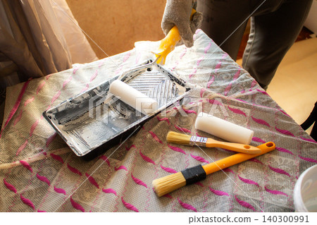 DIY roller with fresh paint. Tray, sleeve, extension pole. Affordable tools, big results. Developing handy skills. Smart budget move for cosmetic home repairs 140300991