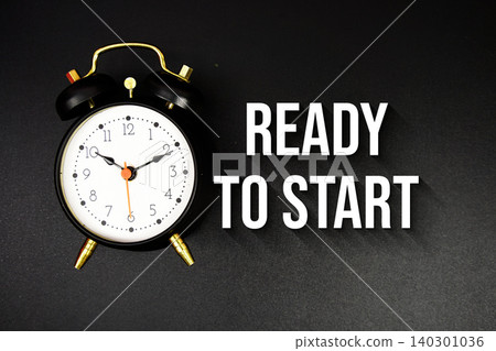 Ready to start text with alarm clock on black background Ready to start text with alarm clock on black background 140301036