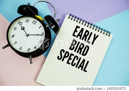 Early Bird Special text written on notepad with alarm clock flat lay on multicolor pastel background 140301073