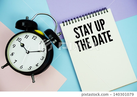 Stay Up The Date text written on notepad with alarm clock flat lay on multicolor pastel background Stay Up The Date text written on notepad with alarm clock flat lay on multicolor pastel background 140301079