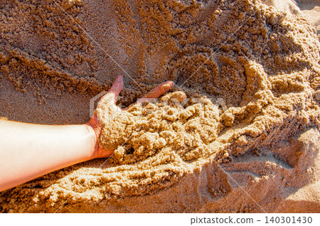 Woman hands touch yellow sand on beach near ocean sea pond, summer sunny day Woman hands touch yellow sand on beach near ocean sea pond, summer sunny day 140301430