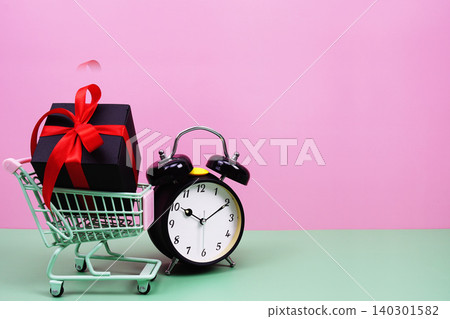 Shopping Cart with alarm clock and Gift Box on pink background with copy space Shopping Cart with alarm clock and Gift Box on pink background with copy space 140301582