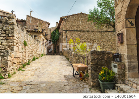 Stone lane with wheelbarrow in medieval Siurana village, historic rural architecture and traditional atmosphere in Catalonia, Spain 140301604