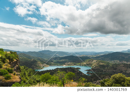 Mountain panorama with turquoise reservoir surrounded by rolling hills and dramatic clouds in Catalonia, Spain Mountain panorama with turquoise reservoir surrounded by rolling hills and dramatic clouds in Catalonia, Spain 140301769