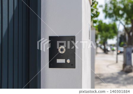 Modern video intercom system installed on residential building entrance wall, smart home access control technology with doorbell camera 140301884