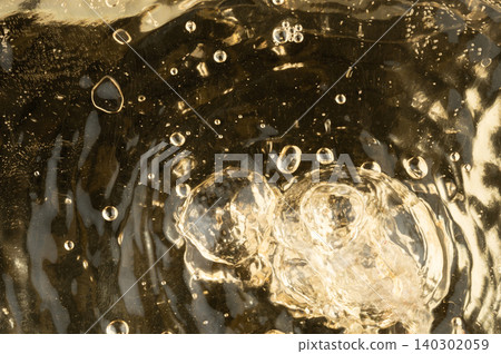 Bubbles rise in a clear liquid within a glass container Bubbles rise in a clear liquid within a glass container 140302059