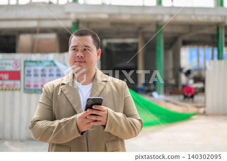 Plus size Isan Thai real estate developer looking away at job site Plus size Isan Thai real estate developer looking away at job site 140302095