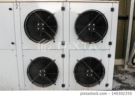 Industrial blast freezer evaporator unit featuring four high-powered black axial fans mounted on a durable white metal casing, designed for rapid large-scale refrigeration and cooling. Industrial blast freezer evaporator unit featuring four high-powered black axial fans mounted on a durable white metal casing, designed for rapid large-scale refrigeration and cooling. 140302350
