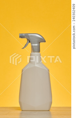 White plastic spray bottle on wooden surface, gray household chemical sprayer White plastic spray bottle on wooden surface, gray household chemical sprayer 140302409