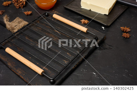 Kitchen still life with cutting board, baking rack, butter and jam on dark background Kitchen still life with cutting board, baking rack, butter and jam on dark background 140302425