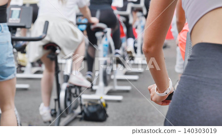 Athletes pedaling on exercise bikes during sports day Athletes pedaling on exercise bikes during sports day 140303019