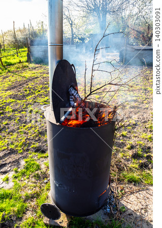 cut branches burn in barrel with chimney in garden cut branches burn in barrel with chimney in garden 140303091