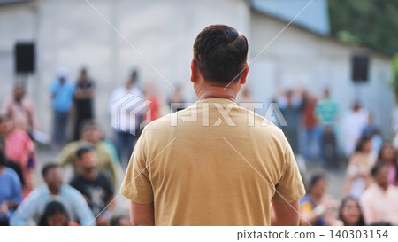 Man watching a crowd celebrating Ganesh Chaturthi festival outdoors Man watching a crowd celebrating Ganesh Chaturthi festival outdoors 140303154