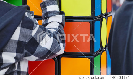 Child's hand on a large colorful puzzle cube toy Child's hand on a large colorful puzzle cube toy 140303155