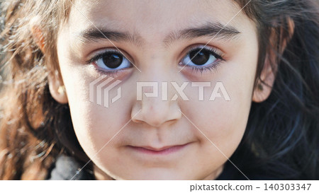 Young girl close-up portrait with dark eyes and innocent expression Young girl close-up portrait with dark eyes and innocent expression 140303347